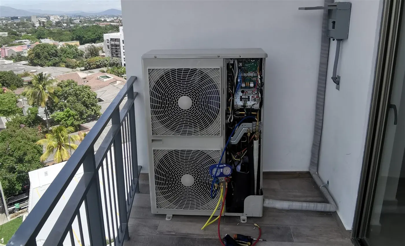 Dos condensadoras de aire acondicionado instaladas por Aire Plus en el balcón de un apartamento en San Salvador